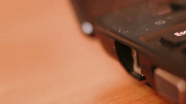 Hand incerting red net connector in netbook or laptop very closeup shot. Selective focus