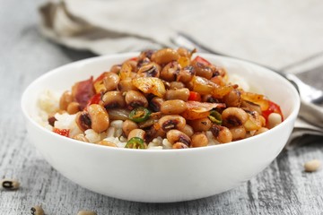 Homemade Hoppin john or carolina Peas served in a white bowl, selective focus