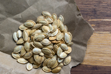 Grilled Pumpkin seeds with sea salt and spices on the wooden background