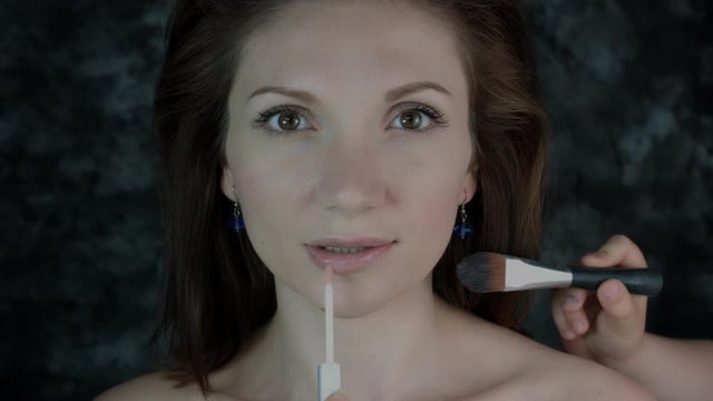 4k Shot of a Woman Posing in Studio with Make-up Brushes on Face