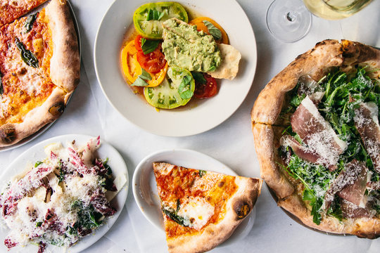 Overhead view of variety of pizza and salad served on the plate