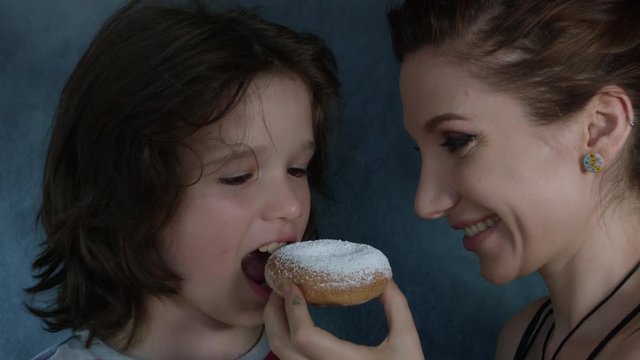 4k Shot of a Cute Child Posing with Mum and Eating Donut