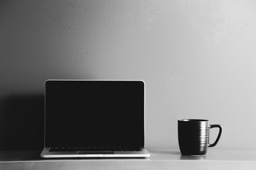 Mug Next to Laptop in Black and White - 131844500