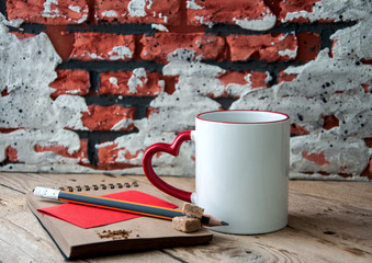 A big cup of coffee and craft paper note with a pencil and brown sugar on a wooden background. Coffee break.