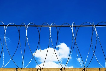 Barbed Wire fence against blue sky
