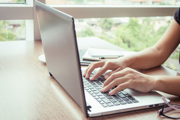 Close Up of woman hands using mobile phone and laptop computer with blank copy space screen for your advertising text message or content business in the Vintage effect.