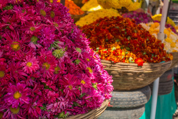 Baskets of chrysanthemums and marigolds at an outdoor market in India