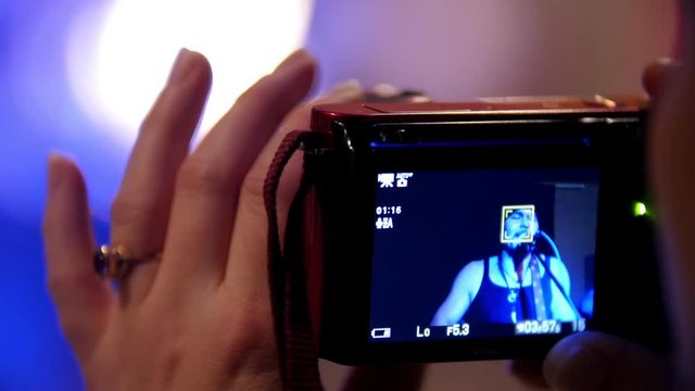 Photographer woman's hand holding gadget during a rock-concert