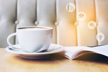Cup of cappuccino with magazine in a coffee shop background with concept idea growing up from the business magazine , vintage tone