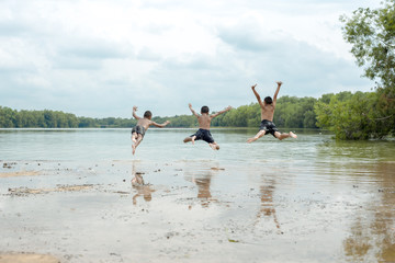 Young boy jumping into lake.