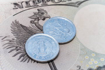 Business and finance concept : Close up of 1 yen japan coin on currency banknote background with copy space.
