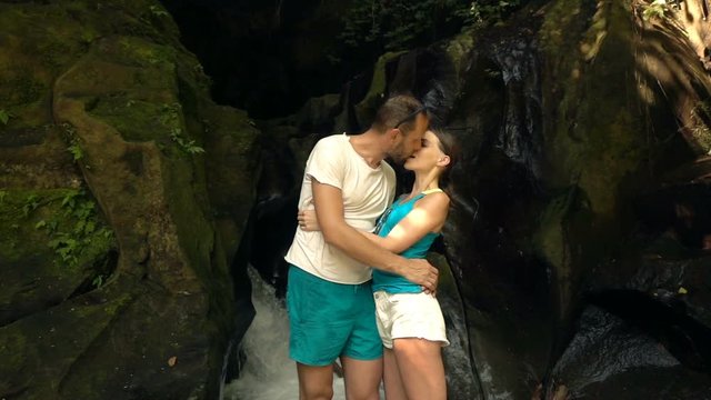 Young couple in love kissing by waterfall, super slow motion 240fps
