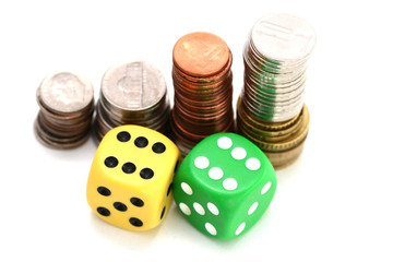 Betting all in concept with ladder of stacked coins and a pair of colorful plastic dice