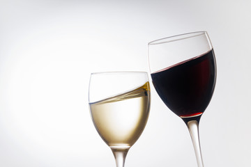 Weißwein und Rotwein im Glas vor hellem Hintergrund