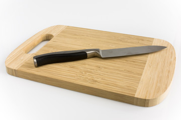 Cuttingboard with kitchen knife isolated on white background. Picture taken in studio with soft-box.