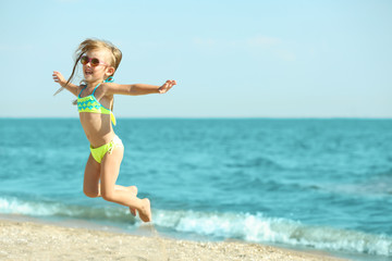 Fototapeta na wymiar Cute girl having fun on beach