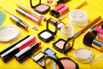 Flat lay of makeup cosmetics on yellow background