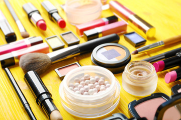Obraz na płótnie Canvas Flat lay of makeup cosmetics on yellow background