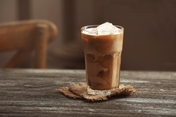 Glass of cold coffee on table