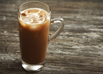 Glass of cold coffee on table