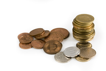 Stack of coins of several currencies, isolated on white background. Still life picture taken in studio with soft-box.