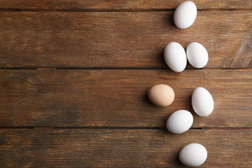 Raw eggs on wooden background, top view