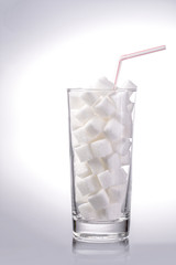 Zuckerwürfel im Glas mit Trinkhalm