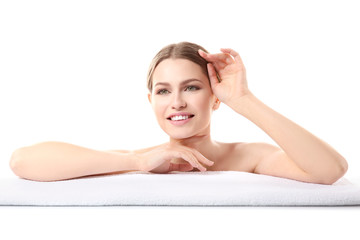 Beautiful young woman lying on towel on white background