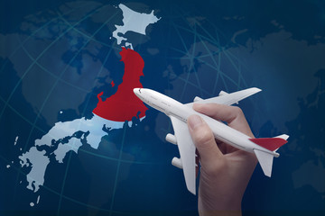 hand holding airplane with map of Japan.