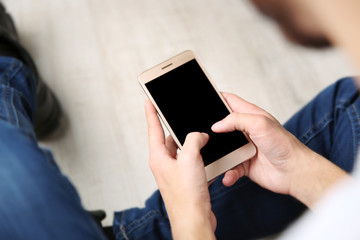 Man sitting on floor and using smart phone