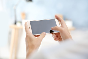 Man using smart phone on blurred background