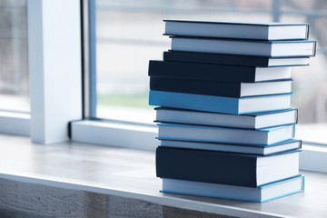 Stack of books on windowsill closeup
