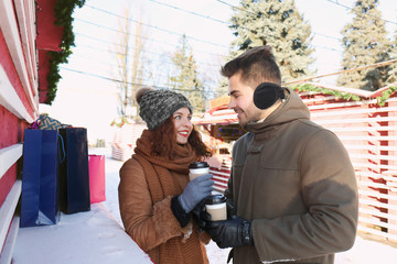 Woman and man drinking coffee on Christmas market