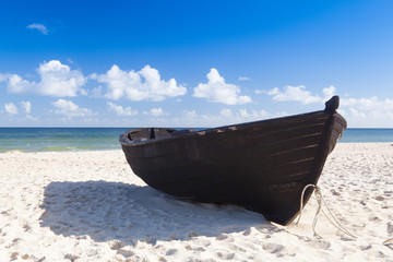 Old wooden fishing boat on the empty beach