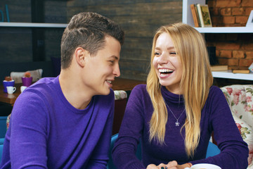 Young man drinking coffee and talking with a woman. Nice meeting friends or lovers.