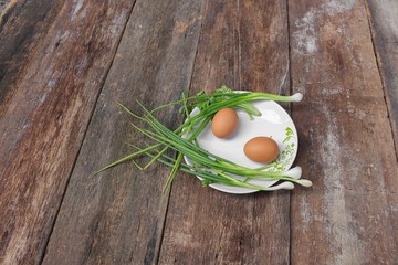 fresh chicken egg on a plate  and onion in wooden table