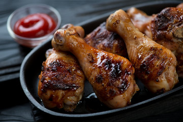 Closeup of barbecued juicy chicken legs, selective focus