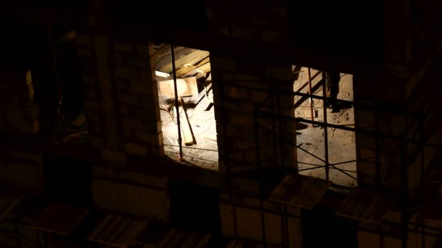 ODINTSOVO, RUSSIA - December 02, 2015. Timelapse clip of building construction. Workers in orange uniform build an apartment building. Winter evening.