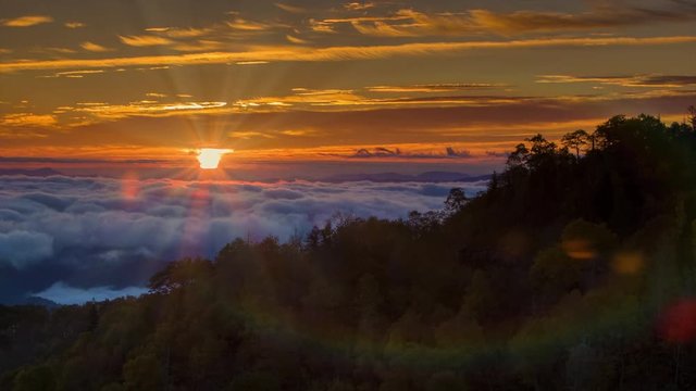 Tilting Up to the Sunrise over the Cloud Covered Smoky Mountains with Sun Rays and Lens Flares following the Camera Movement