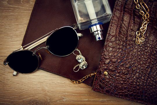 Top view of female fashion accessories. Perfume with sunglasses