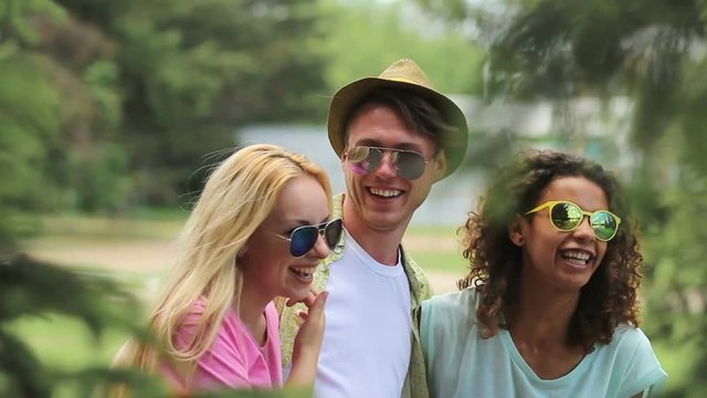 Several close friends joking around, hugging and dancing at music festival
