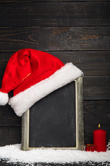 Obraz na płótnie Canvas Red Santa hat on the chalkboard with snow