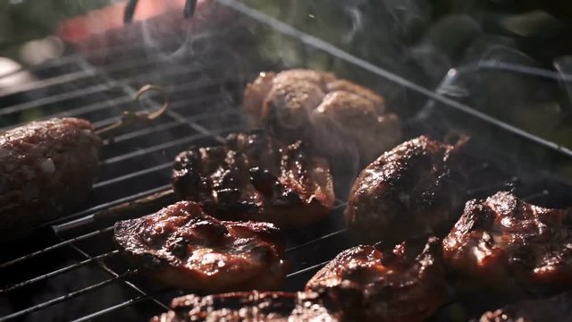 Grill, Frying Fresh Meat, Chicken Barbecue, Sausage, Kebab, Hamburger, vegetables, BBQ, Barbecue, seafood. grilled peppers and onion. Closeup sunny outdoor Chef turns the meat on the grill