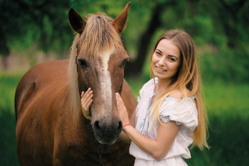 Fototapeta premium outdoor portrait of young beautiful woman with horse