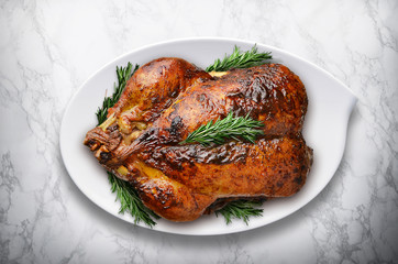 New Year roasted turkey with rosemary on white marble table.