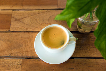 cup of fresh coffee with coffee beans on wooden table