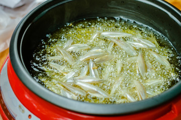  close up of fried small fish in pan sale at asian street market ,cooking style asian, asian kitchen