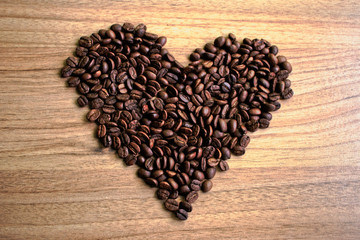 Coffee beans in a heart shape on a wooden table
