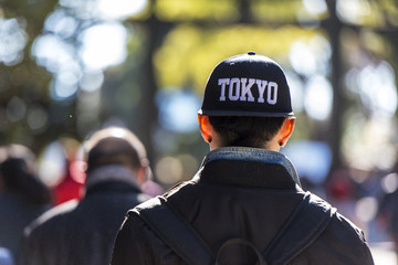 Obraz premium A young man dressed in fashion cap going in a park in Tokyo Japan