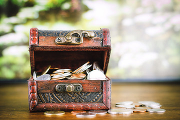 Saving money concept preset putting money coin stack growing business on bright light glowing bokeh background, business finance wealth and success concept.